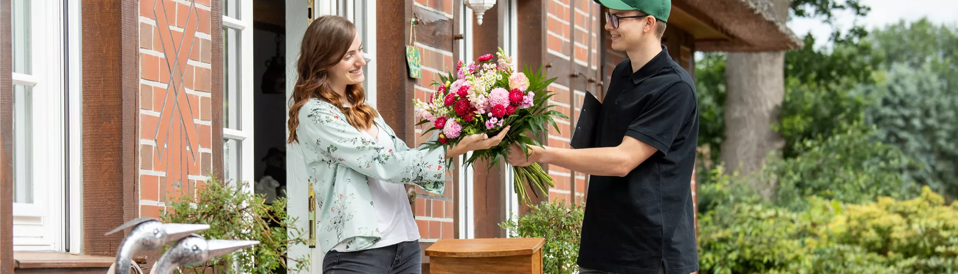 Lieferservice - Lieferant übergibt Blumenstrauß Lieferservice - Lieferant übergibt Blumenstrauß